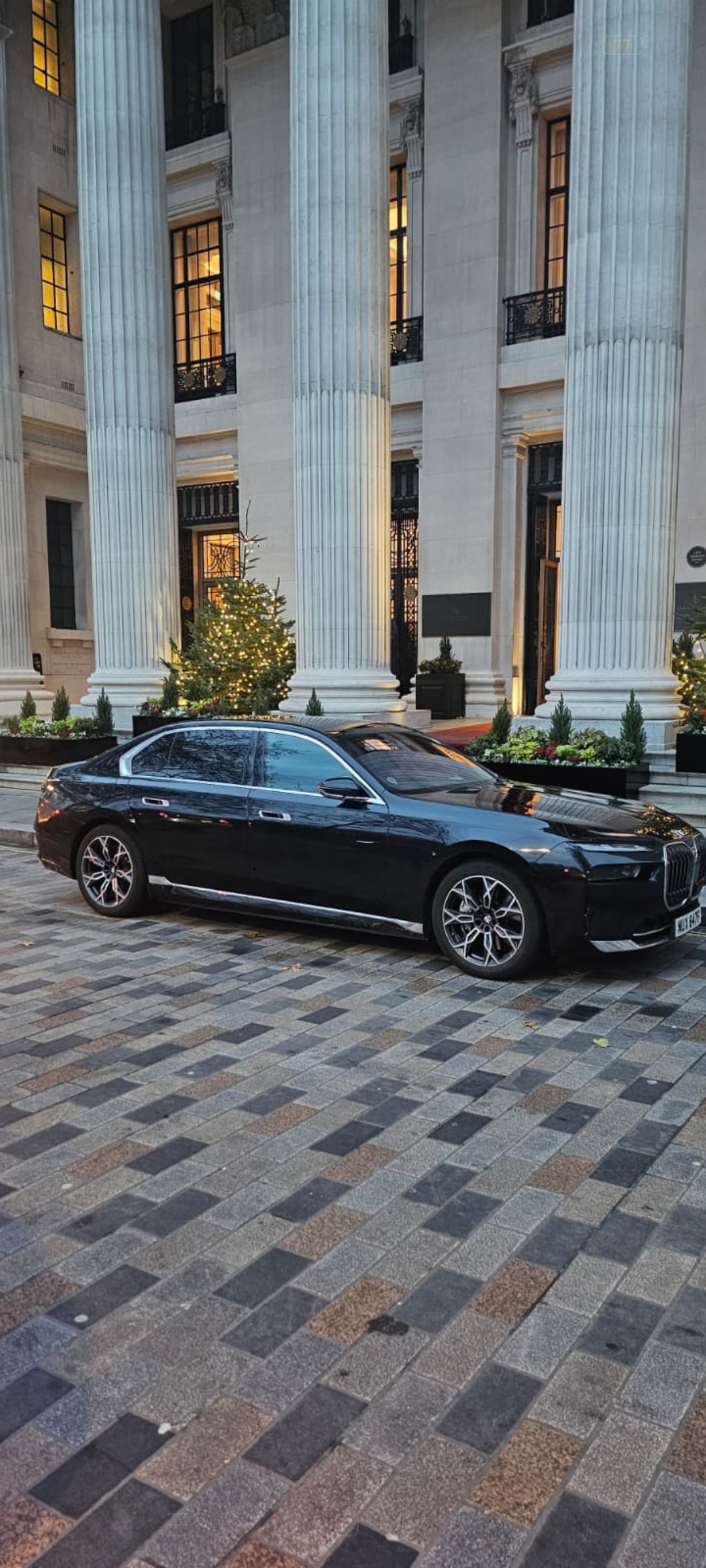 BMW i7 Chauffeur Service — the all-electric flagship outside the fluted stone columns